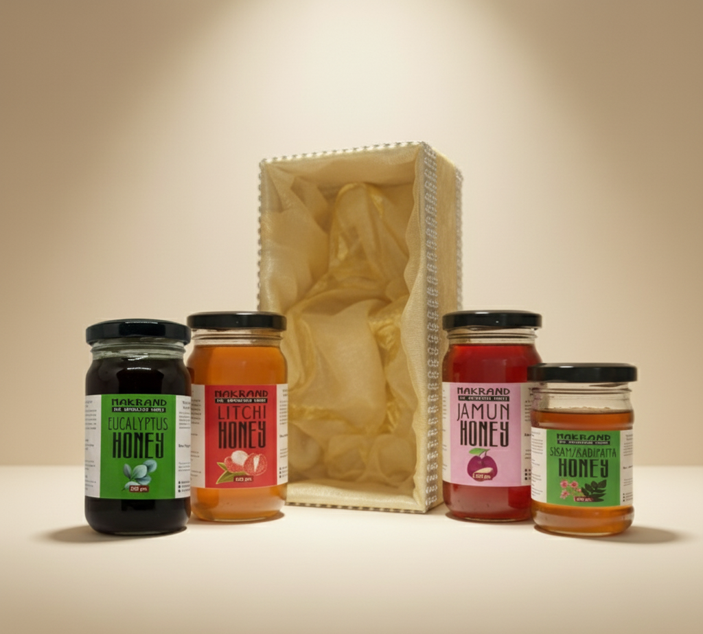 Five jars of honey with labels in front of a gift box on a beige background